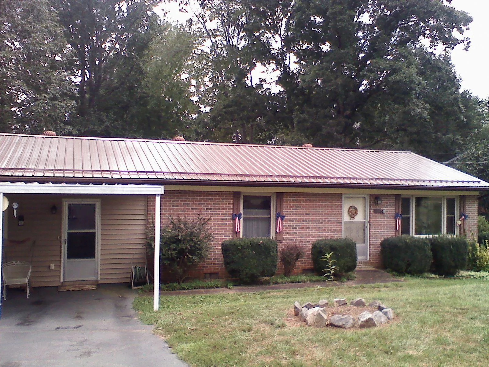 Bronze metal roof and carport on a brick ranch home — Roof Repair work by our crew in White Lake